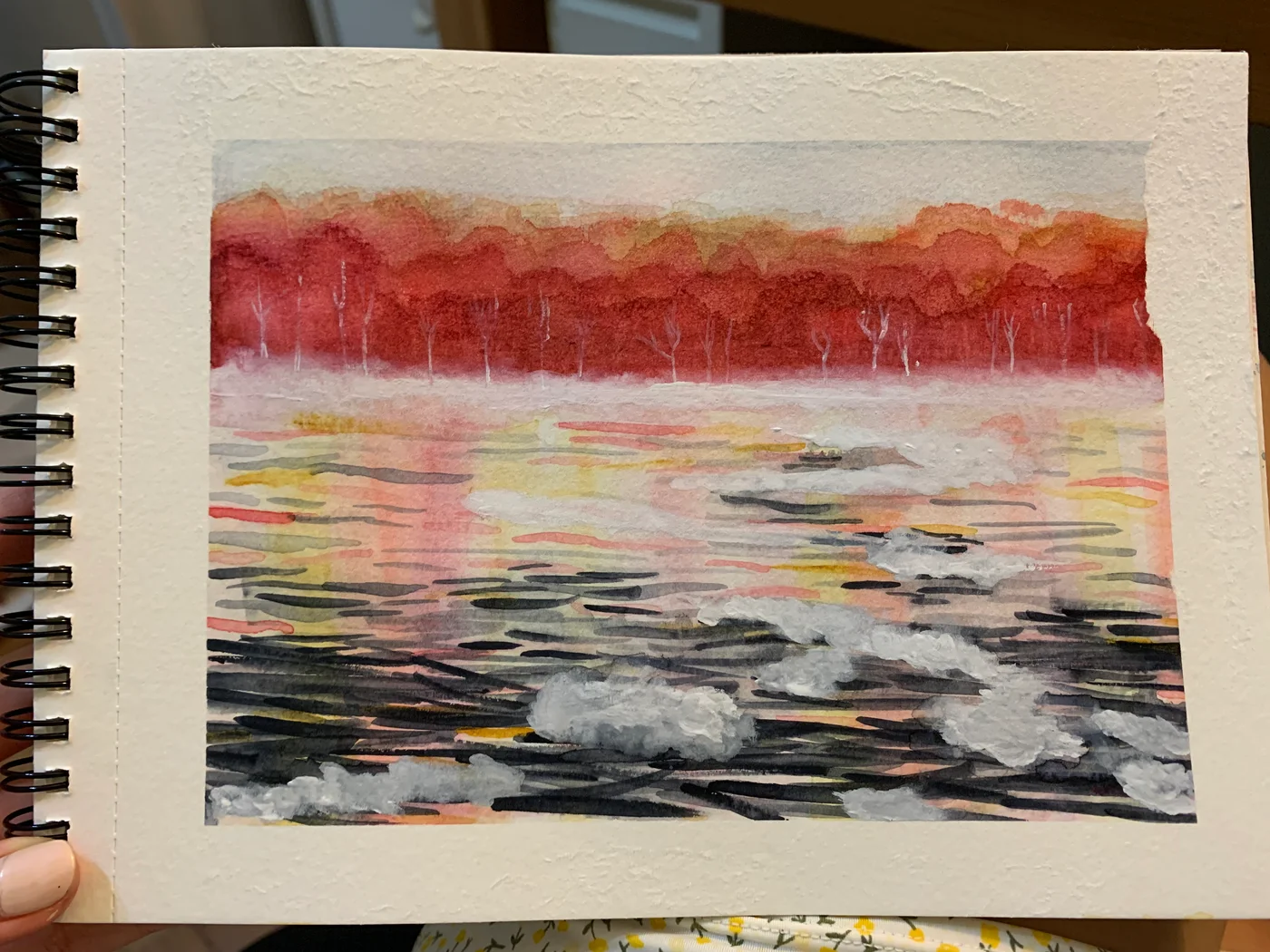 Sketchbook painting of rippling water reflecting a line of red autumn trees.