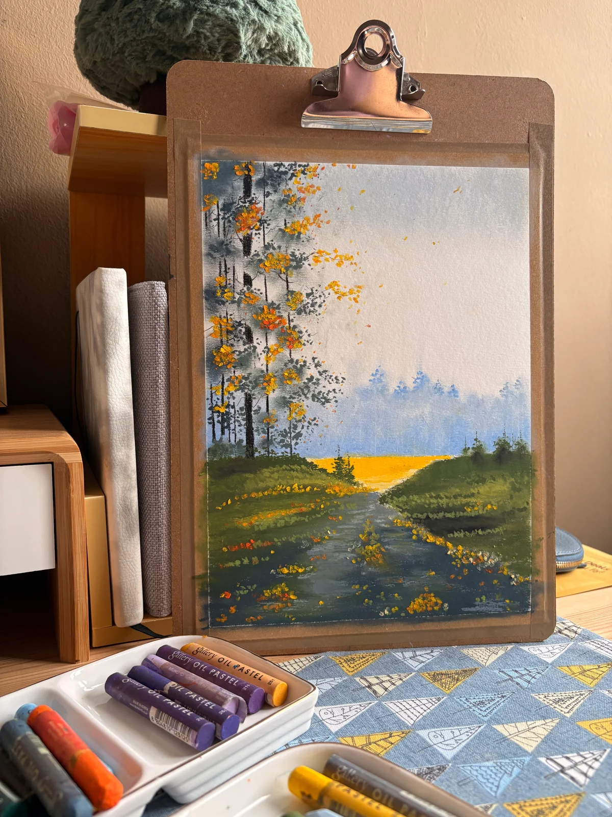 Painting of a country path beside slender autumn trees and a sunlit yellow field.